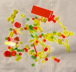 Batch of yellow, orange, and green fluorescent Lego finishing pieces.
