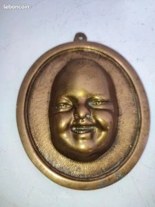 antique bronze medallion of a laughing child in good condition