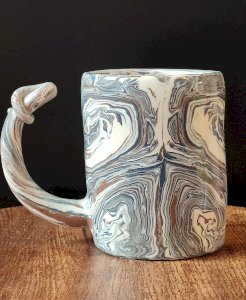 Handcrafted ceramic mug with marbled design, one-of-a-kind piece.