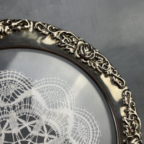 Napperon en dentelle aux fuseaux sous verre cerclé métal argenté décor de roses