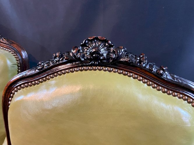 Paire de larges fauteuils XIXe en cuir vert de style Louis XV