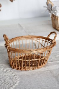 Round wicker storage basket with woven handles.