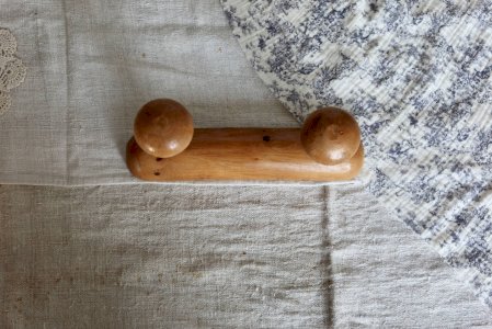 Vintage wooden hook with two round hooks.