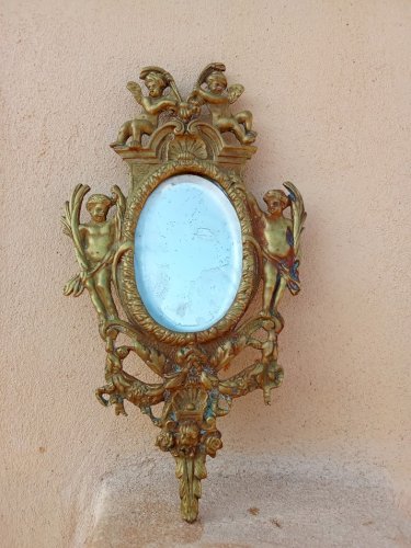 Petit miroir en bronze au décor danges.
