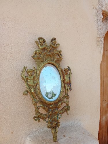 Petit miroir en bronze au décor danges.