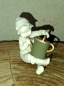 petite sculpture ancienne en porcelaine enfant à larrosoir en bon etat