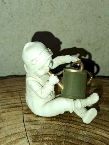 petite sculpture ancienne en porcelaine enfant à larrosoir en bon etat