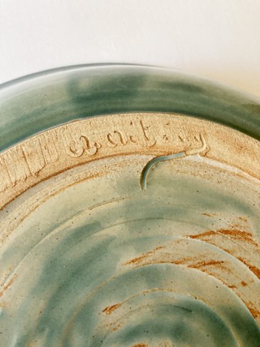 Plat en grès vert céladon signé