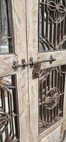 Porte en tek ciselé avec panneaux ajourés en fer forgé
