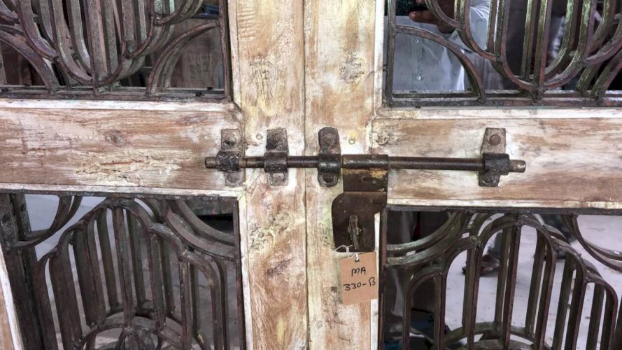 Porte en tek ciselé avec panneaux ajourés en fer forgé