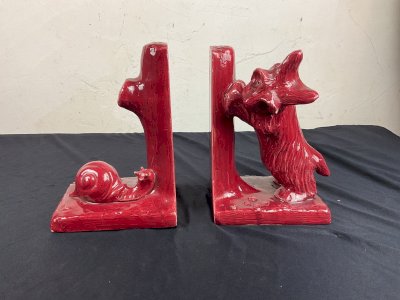 Art Deco ceramic bookends featuring a dog playing with a snail.
