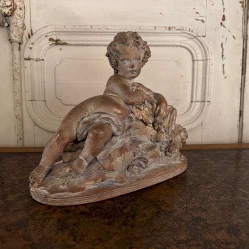 Statue en terre cuite représentant Bacchus enfant sur un tonneau M3599