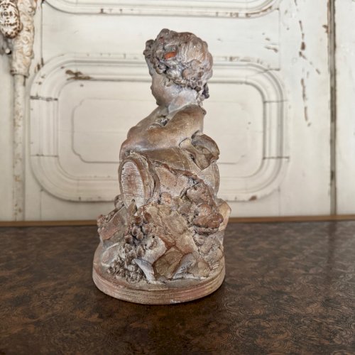 Statue en terre cuite représentant Bacchus enfant sur un tonneau M3599