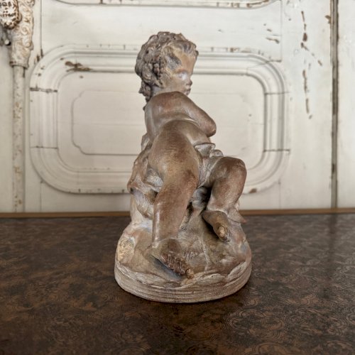Statue en terre cuite représentant Bacchus enfant sur un tonneau M3599