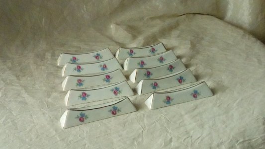 SUITE DE 10 PORTE COUTEAUX EN PORCELAINE DECOR FLORAL**