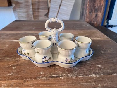 Support and 6 eggcups in antique porcelain with a barb decoration.