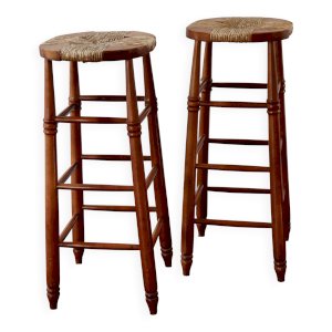 Antique wooden bar stool with a straw seat.