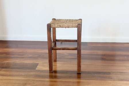 Rustic antique stool made of wood and straw