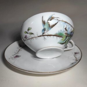 Antique fine porcelain cup from Limoges with a bird design.