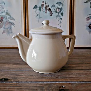 Round vintage ceramic teapot in cream color, art deco style